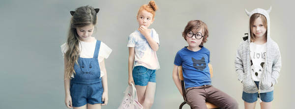 Bambini posano con alcuni abiti in vendita su Smallable